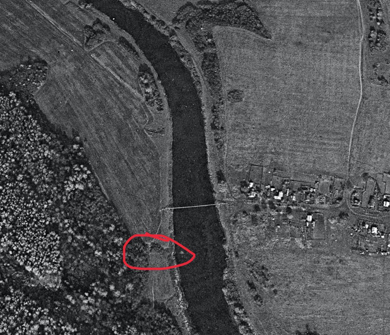 Aerial map view of a river bend with a red mark indicating a specific location.